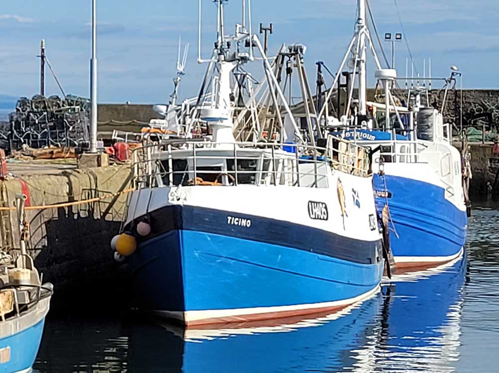 Image of Port Seton Harbour wiht fishing boats and reflections in the water.